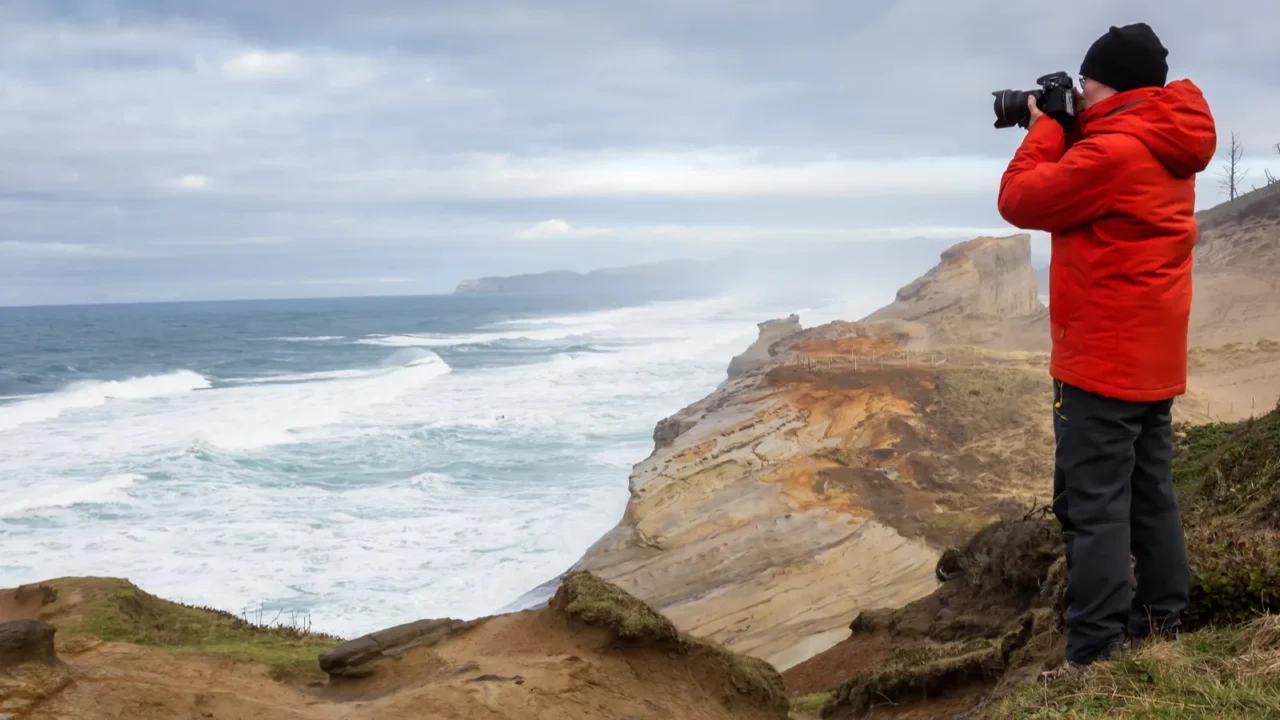 adventurous man with a camera is standing taking pictures of