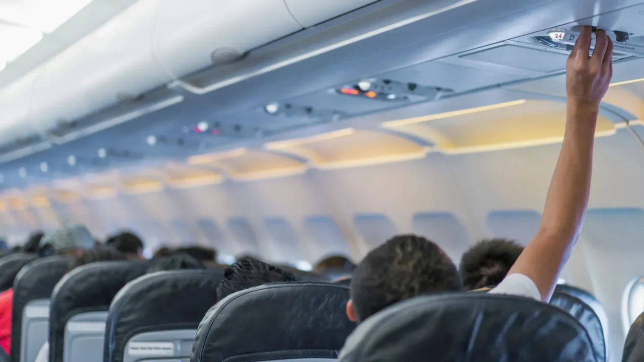 asian couple people cabin crew hand up to adjust console