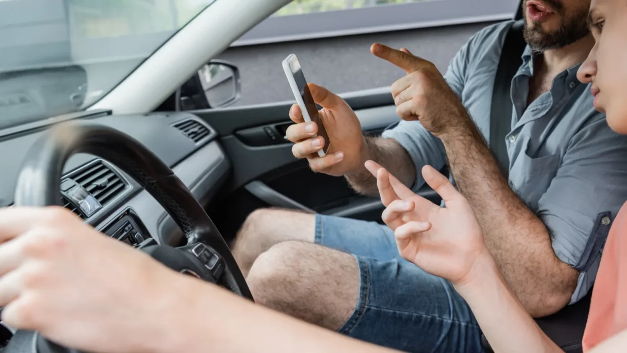 bearded father pointing at smartphone while using online map sitting