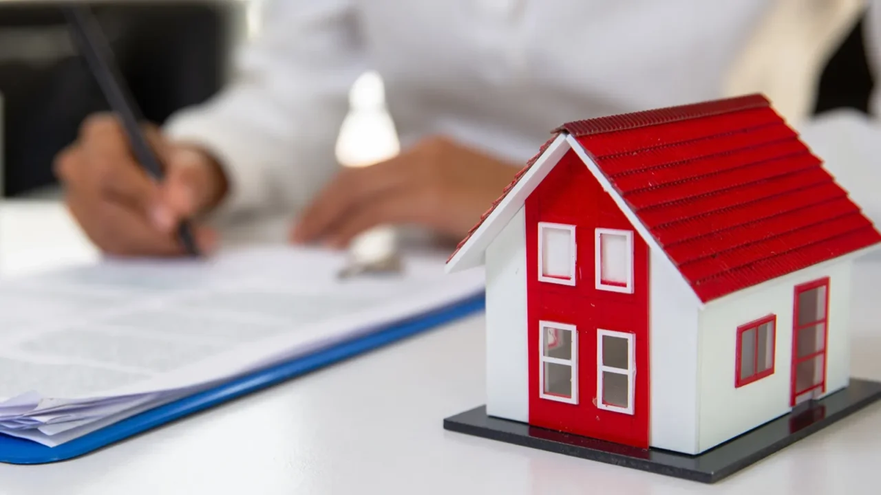 businessman signs contract behind home architectural model fema