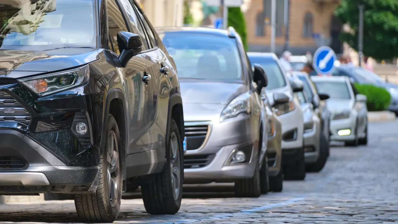 city traffic with cars parked in line on street side