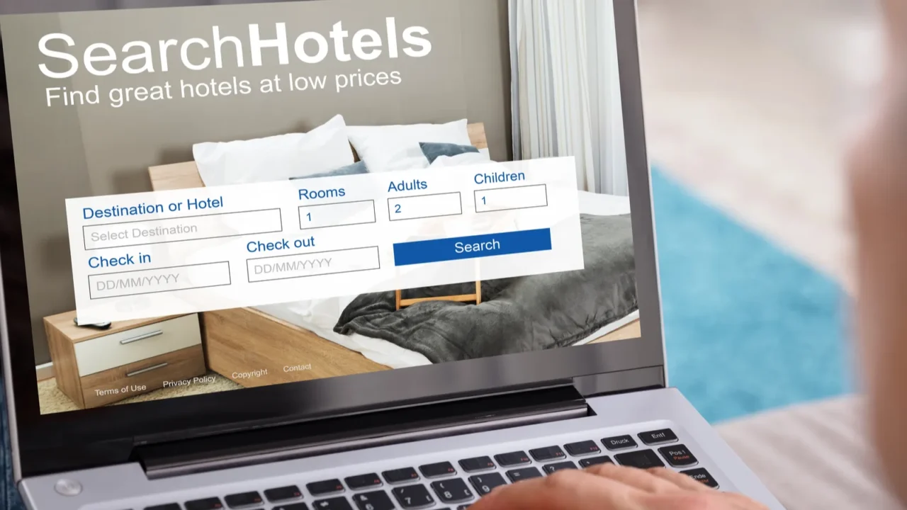 closeup of a persons hand searching hotels with low prices