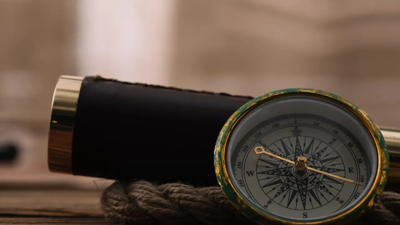 close up view of compass near telescope and rope cable