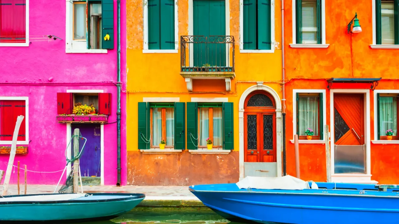 colorful architecture and canal with boats in burano island venice