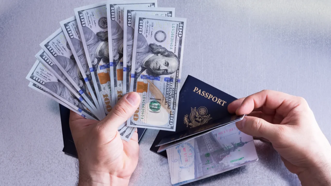 conceptual hand holding dollar bills and passport