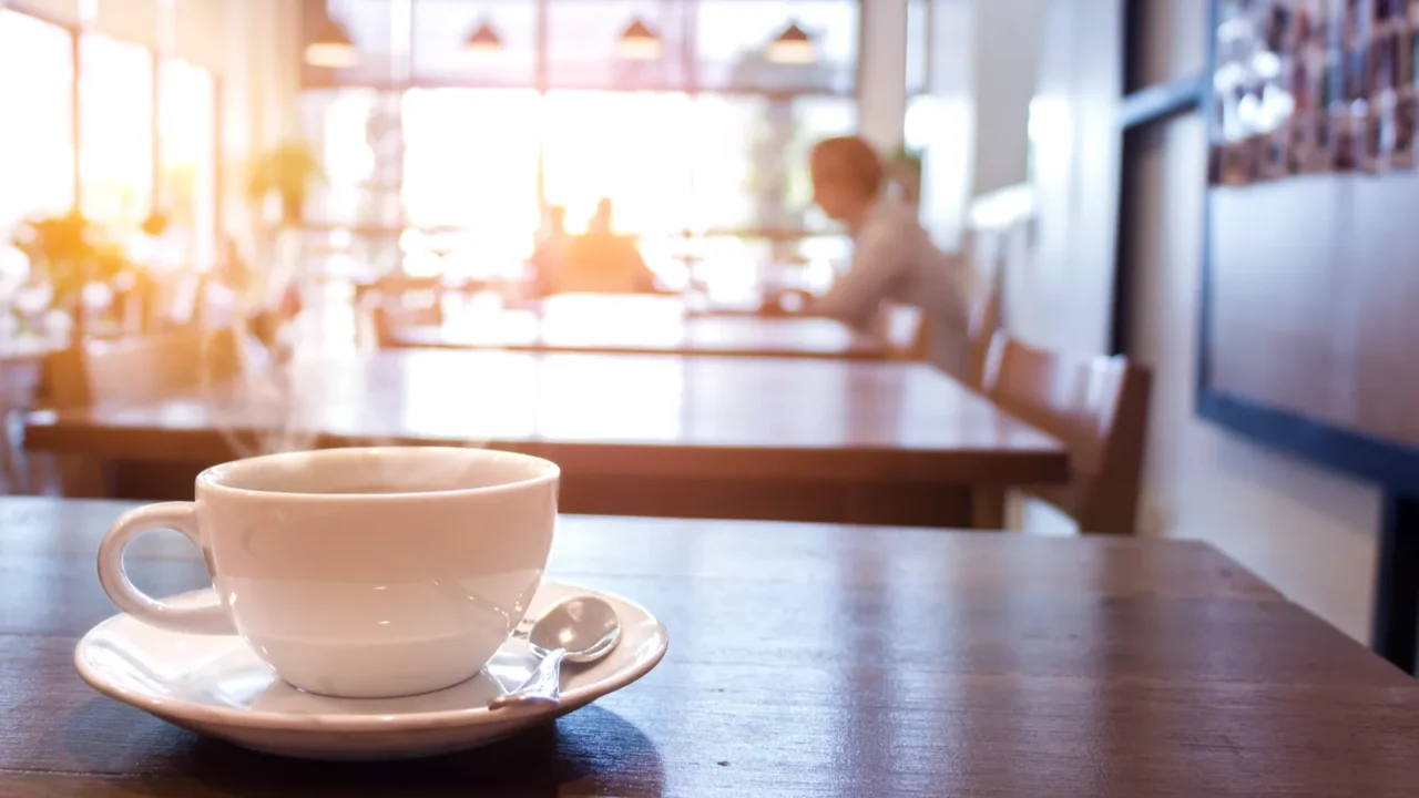 cup of coffee with smoke on table in cafe