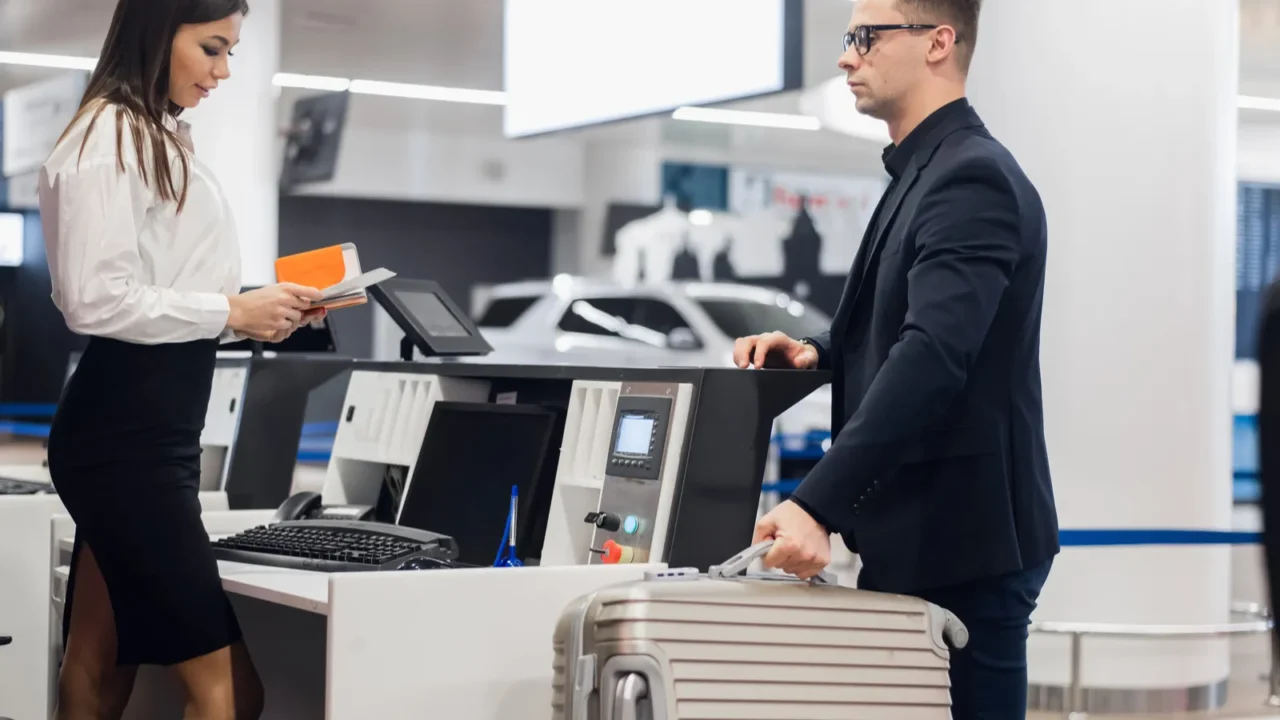 handsome businessman handing over air ticket at airline check in