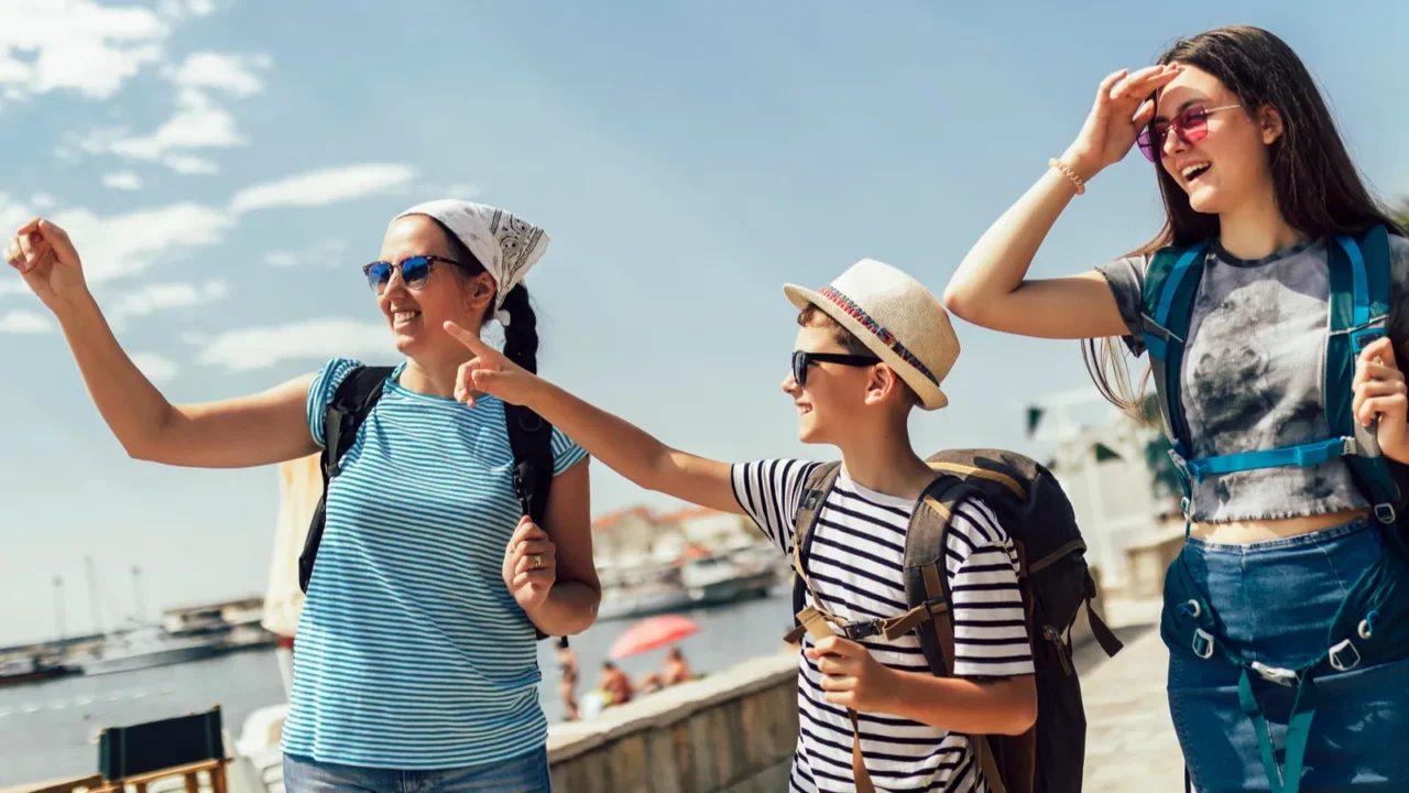 happy mother son and daughter walking together at seacoast with