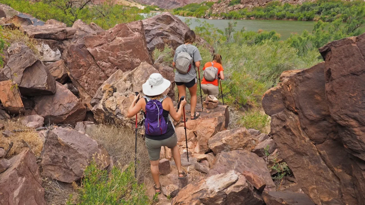 hikers on a trail by the colorado river in the
