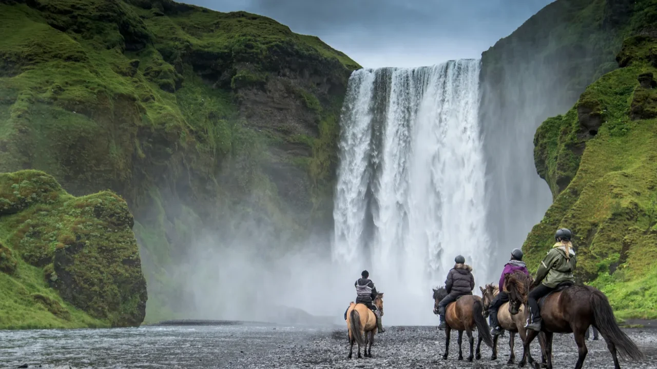horse rider near skogafoss waterfall in summer iceland