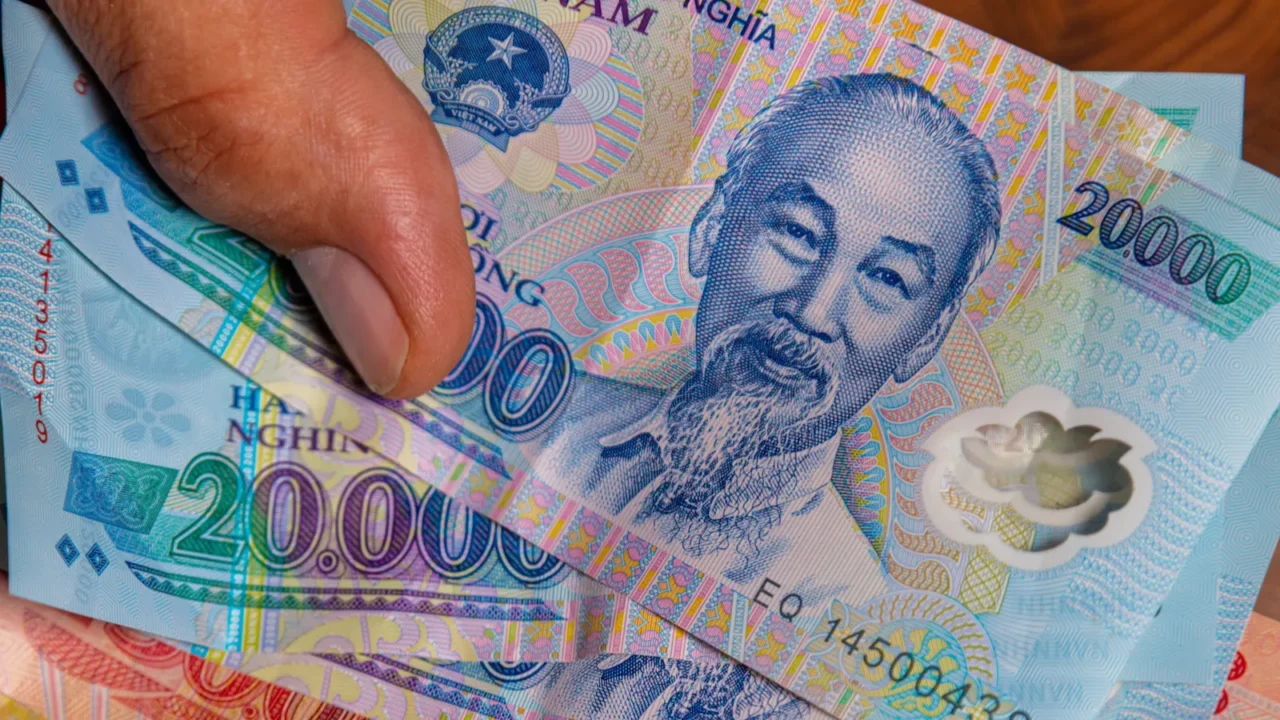 male hand holds a fan of vietnames dong banknote