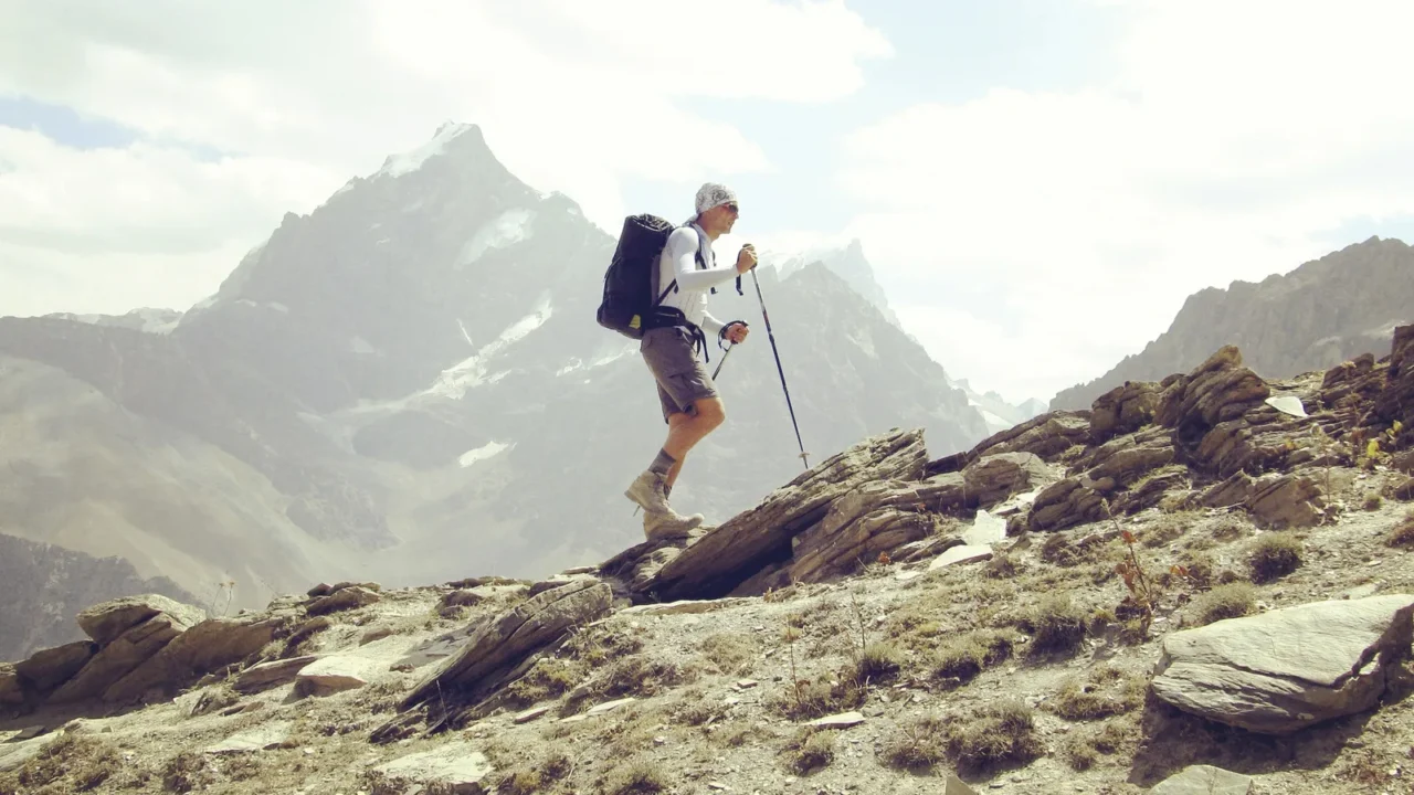 Man tourist walking the mountains with a backpack.