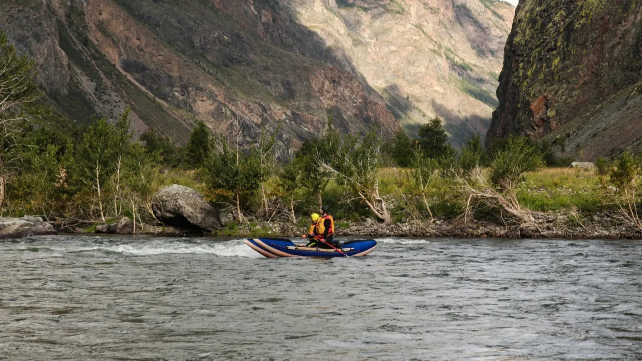 people on kayaks rafting on mountain river and beautiful landscape