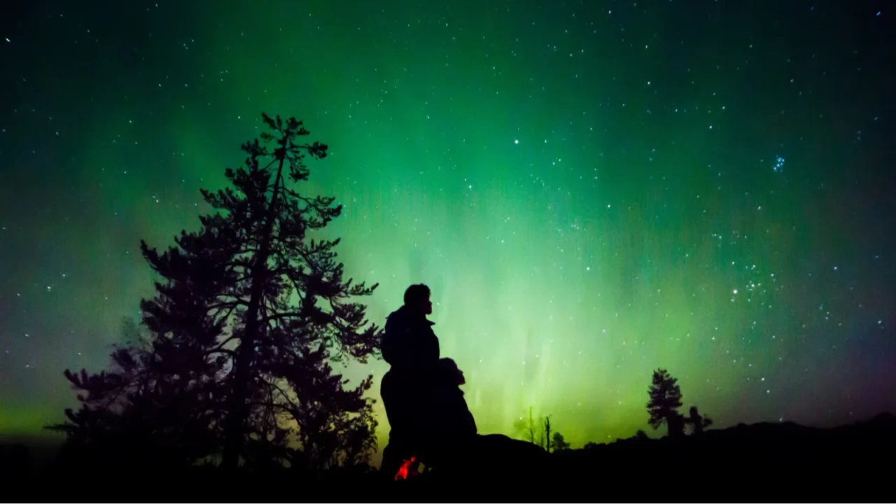 people silhouettes over aurora borealis