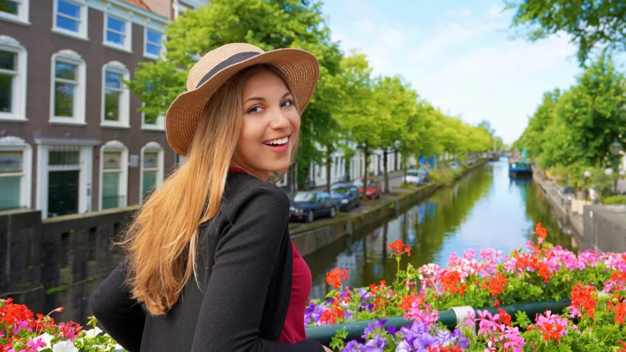 portrait of young tourist woman between flower pots looking at