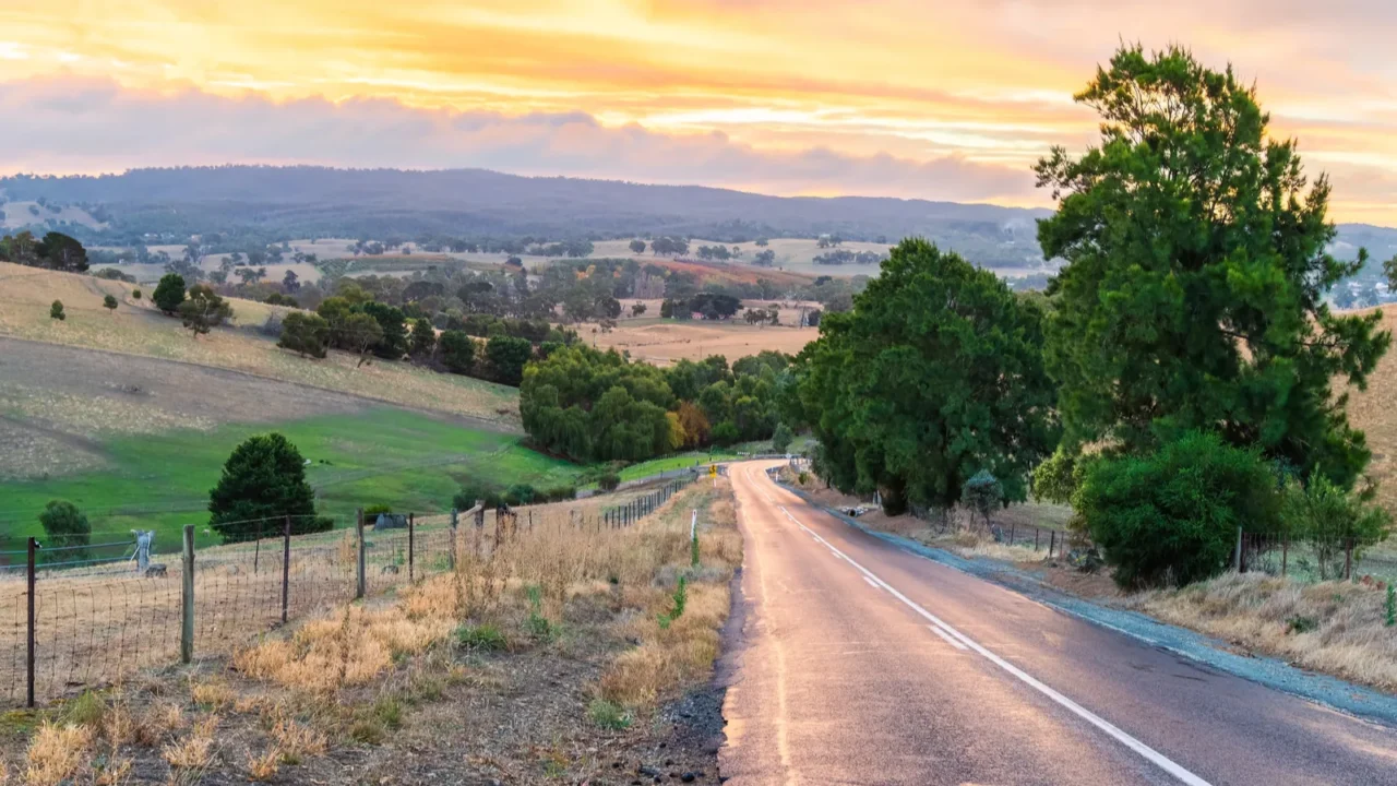 road through adelaide hills farms during winter season at sunset