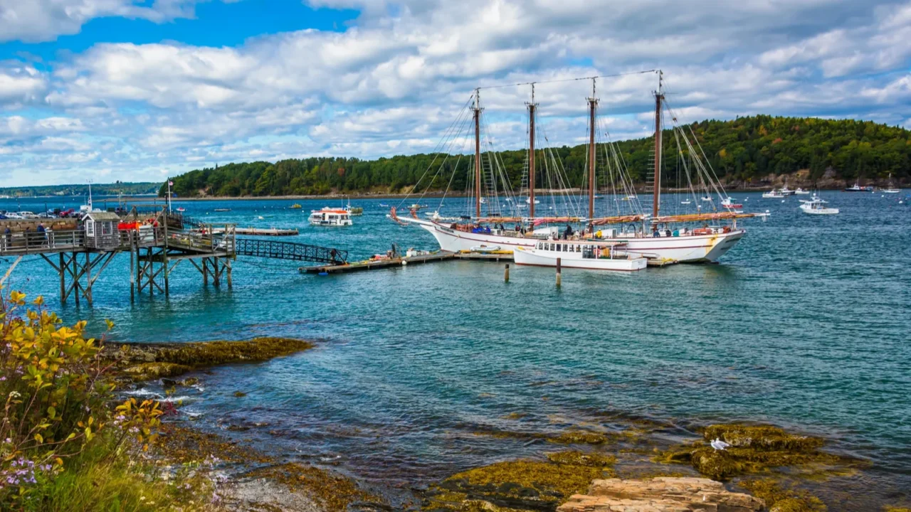 rocky coast and view of boats in the harbor at