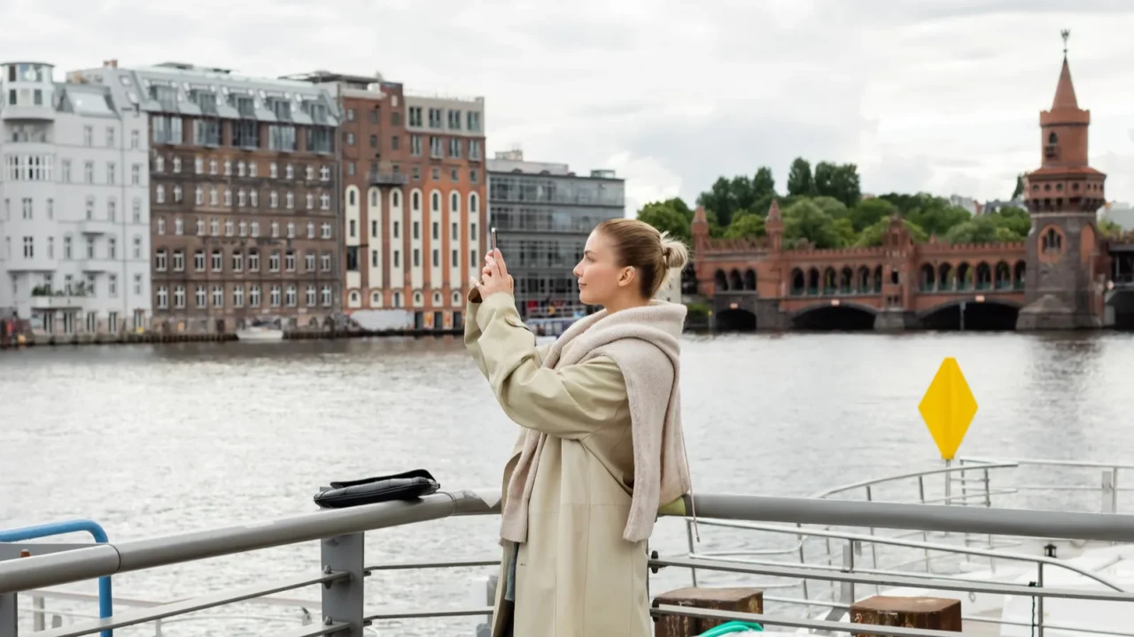 side view of young woman taking photo on pier in