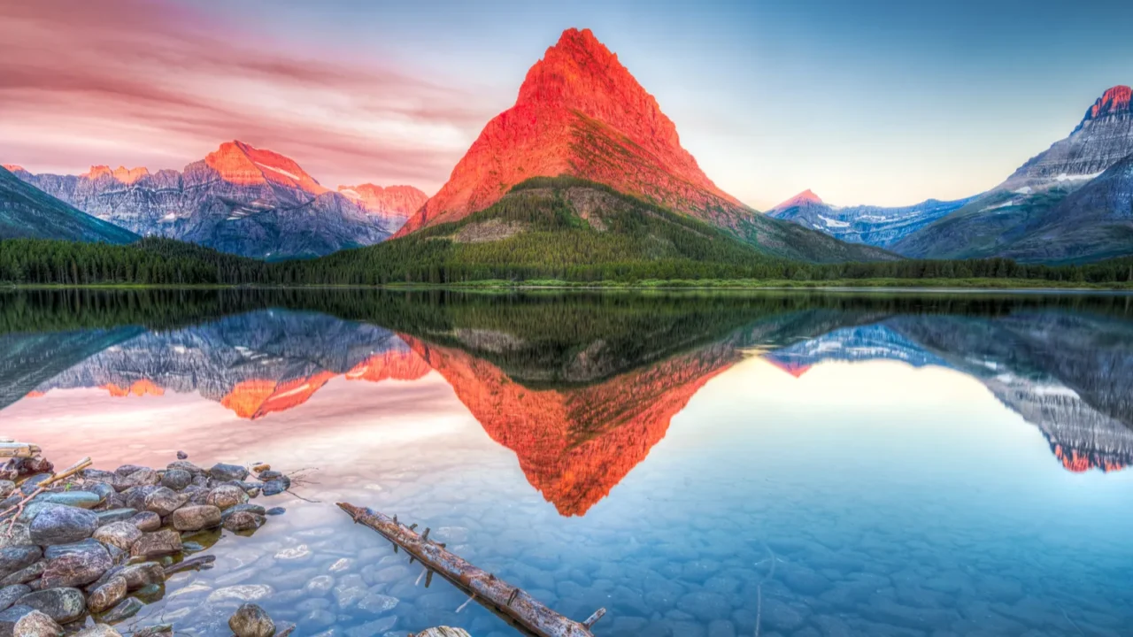 stunning reflections on swiftcurrent lake in northern montana at sunrise