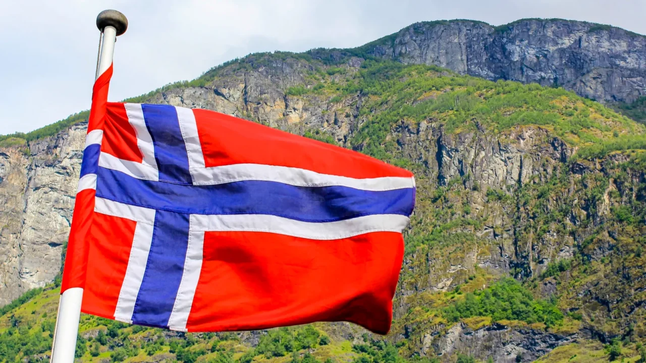 the national flag of norway in the rough wind and