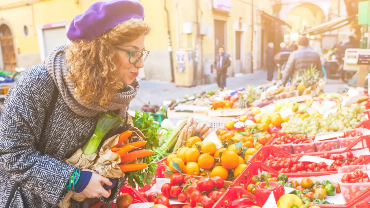 vegetarian vegan young woman buying vegetables at local market