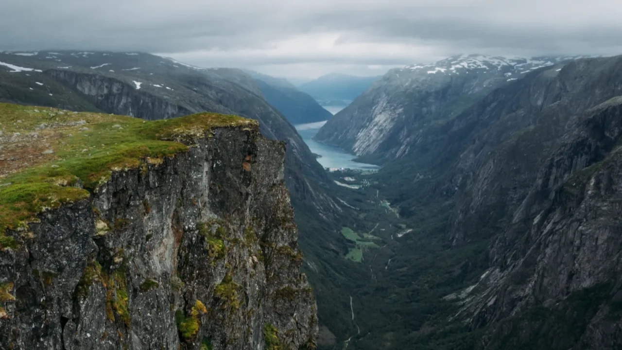 view of rocks and grassy cliff mountain river on background