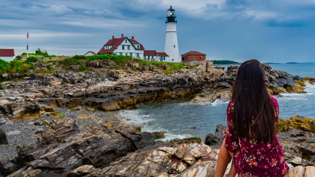 woman mesmerizing the view of portland head lighthouse in portland