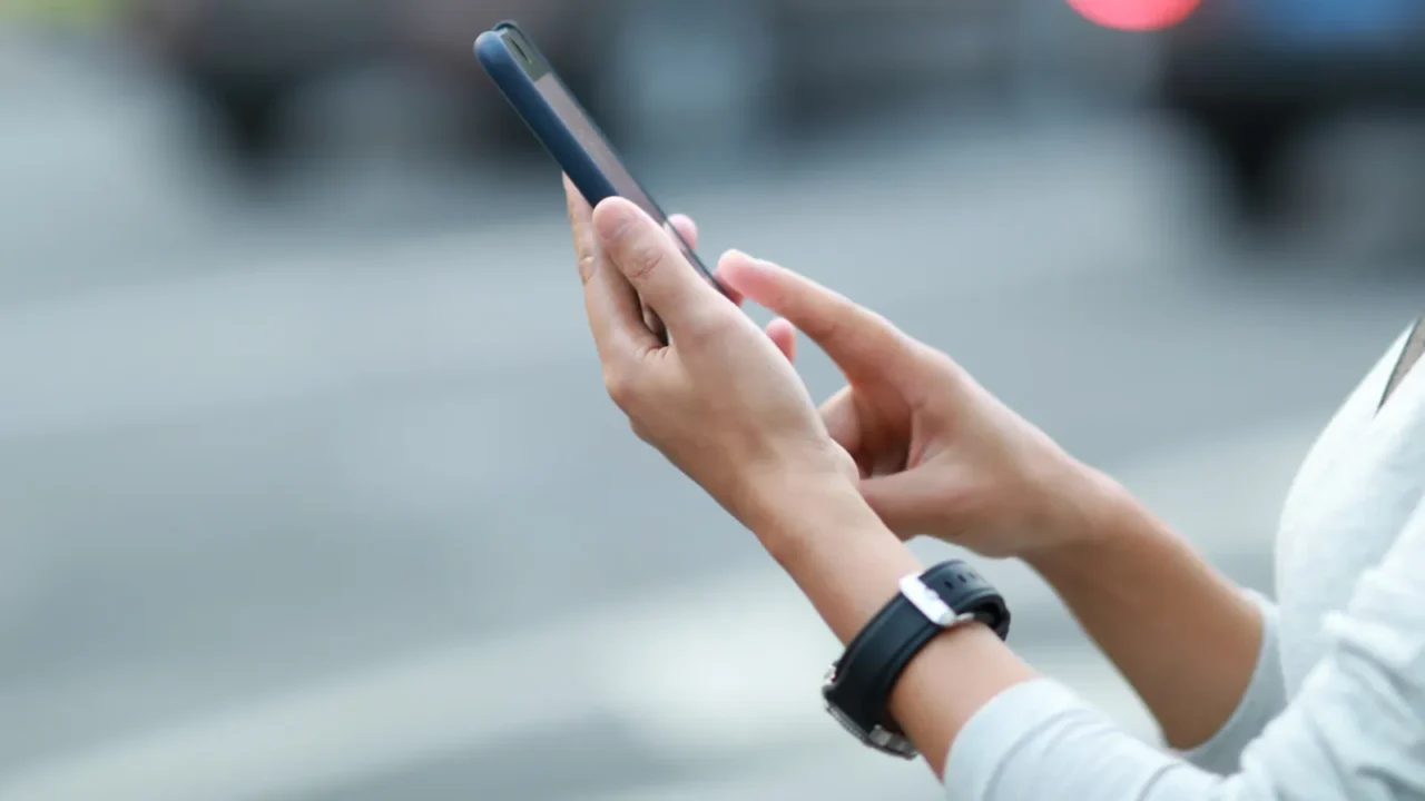 woman using smartphone at city for ridehailing