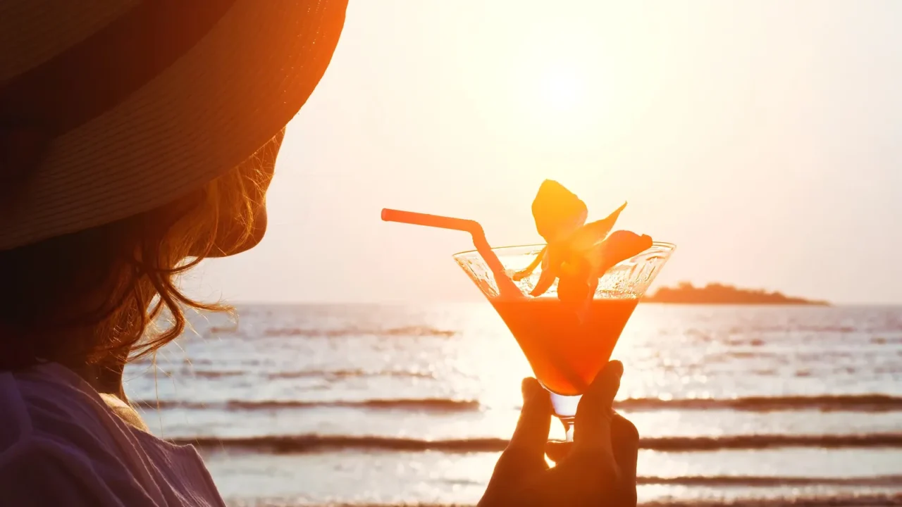 woman with cocktail on the beach