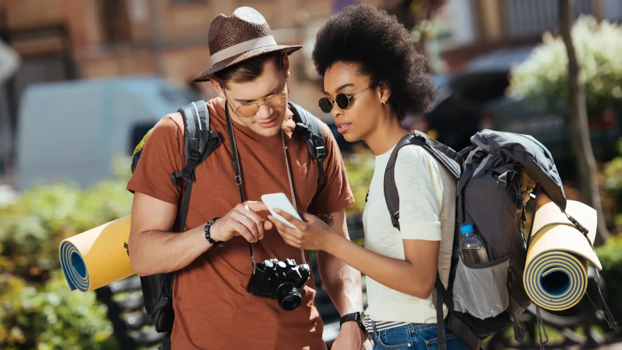 young couple of tourists with smartphone looking for destination