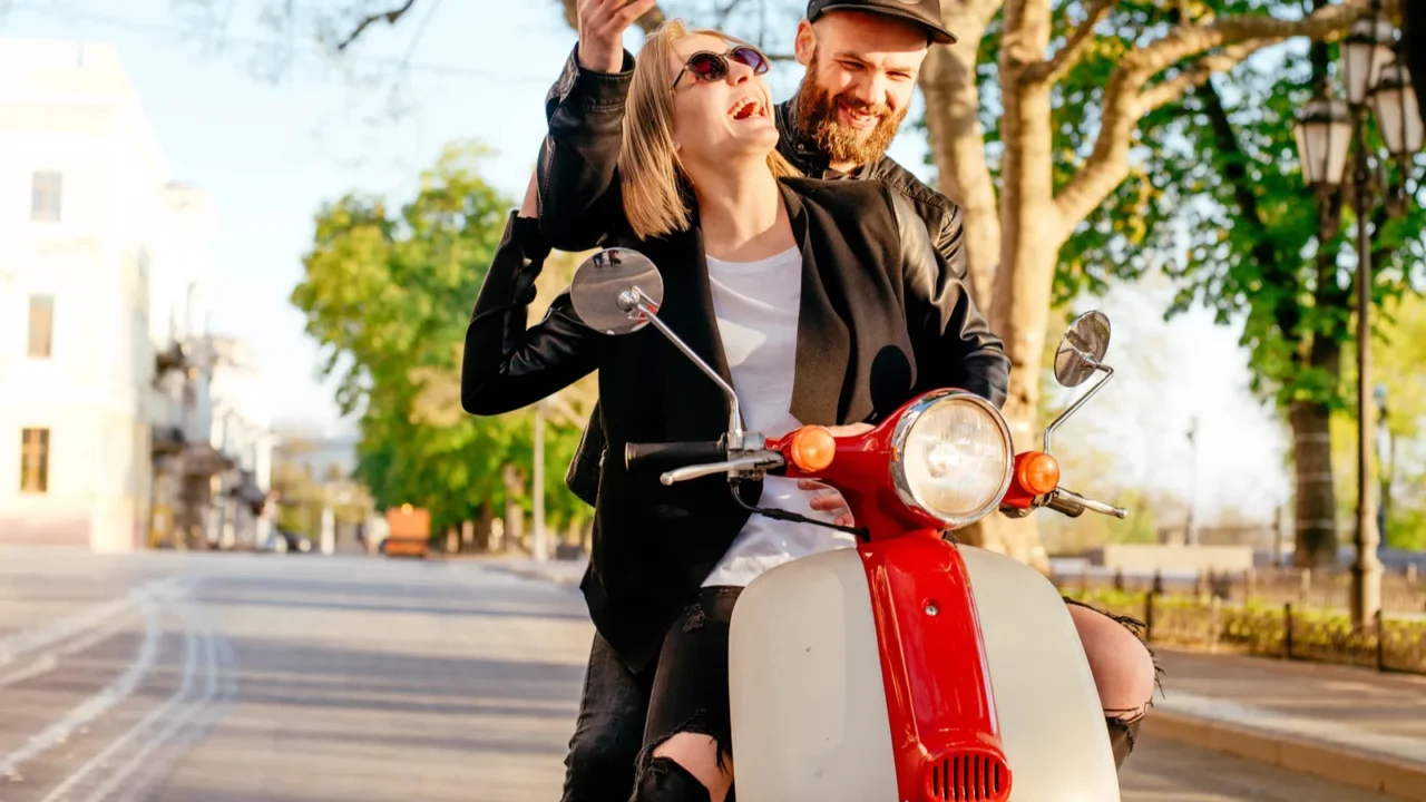 young couple posing on scooter
