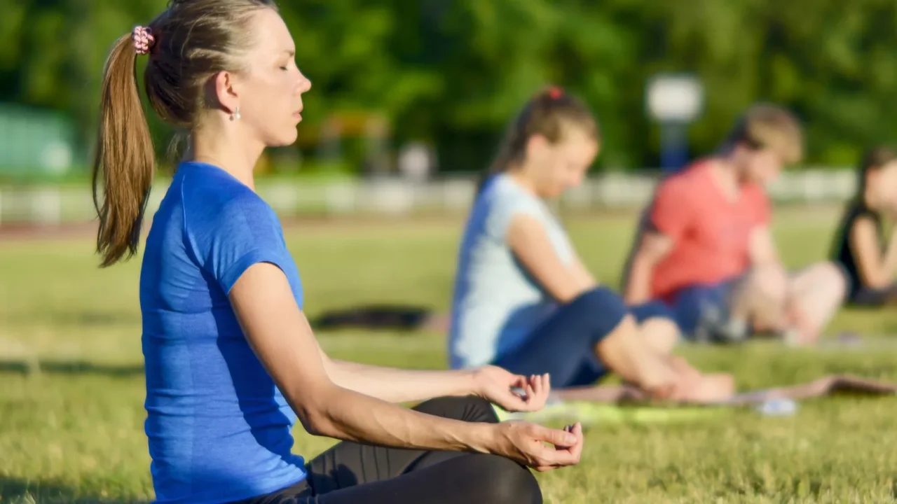 young woman in a blue shirt doing yoga in a