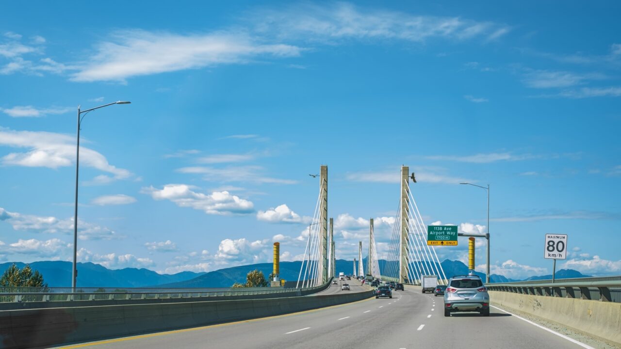 Golden Ears Bridge, connecting Maple Ridge to Langley. Traffic on a cable-suspended bridge spanning across Fraser River on a sunny summer day. Vancouver Canada. Cars drive through an elevated highway