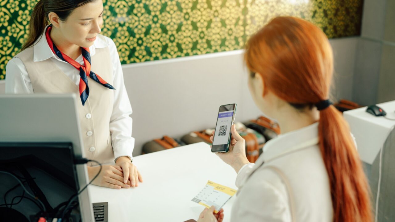 Airplane passenger checking in using electronic boarding pass on phone.