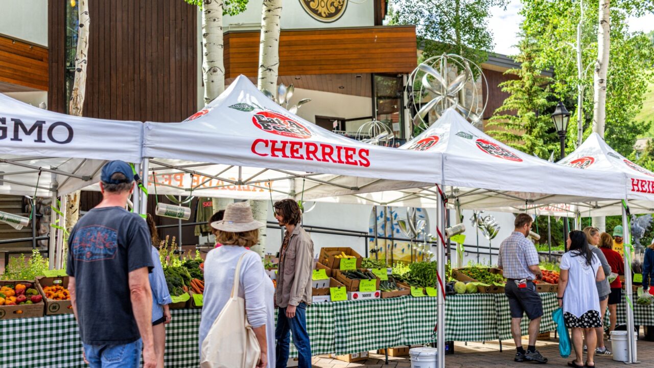 Vail, USA - July 3, 2022: Farmer's market in Colorado with food vendors local stall for fruit non-gmo selling fresh grocery produce, farm vegetable