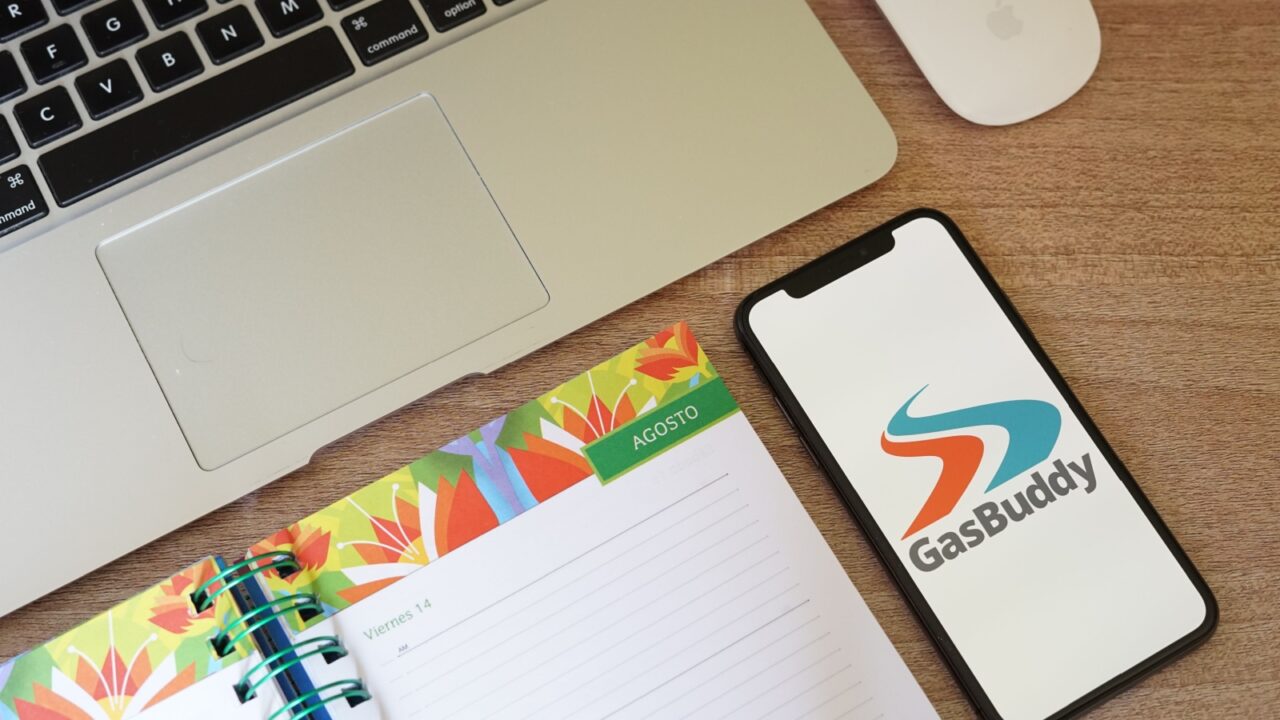 Gasbuddy App with Macbook and Colored Agenda. GasBuddy is an app provides prices of nearby gas stations.