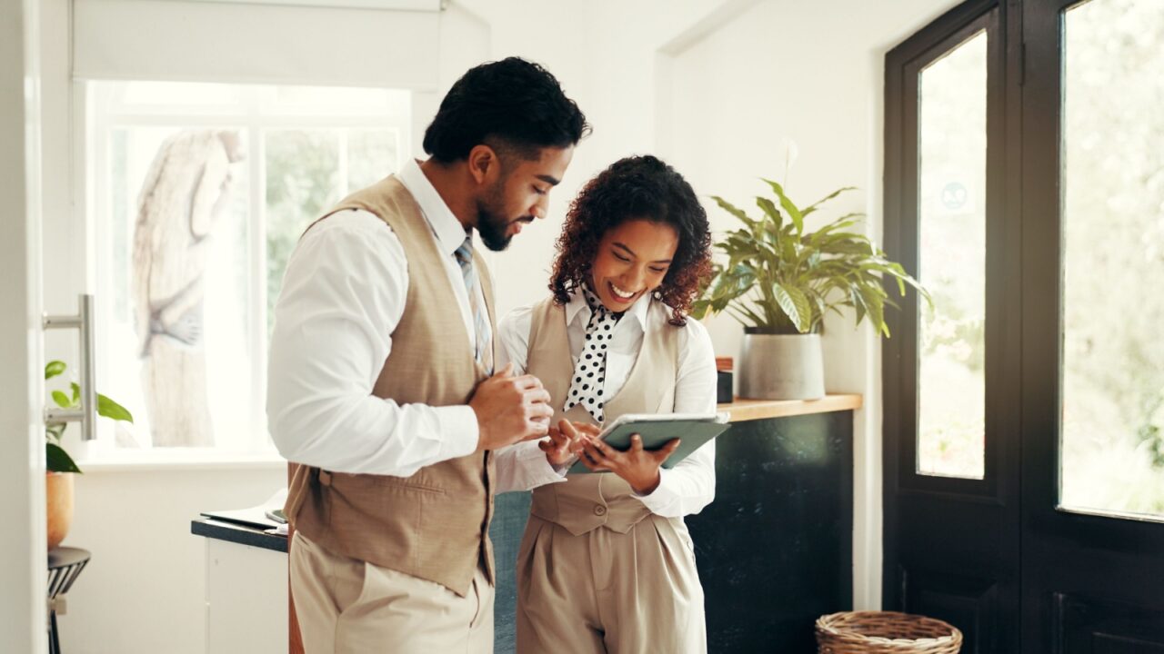 Teamwork, tablet and people in reception for hotel booking, concierge and guest check in. Hospitality industry, manager and online administration in lobby for resort, reservation enquiry or schedule