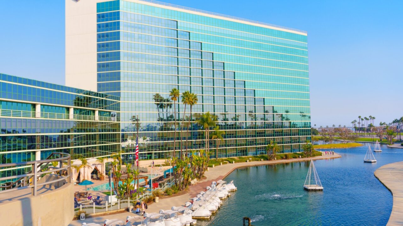 Long Beach, California - January 11, 2025: Modern Hyatt Regency hotel features large glass windows, a marina with swan-shaped boats, highlighting a beautiful waterfront location in Long Beach
