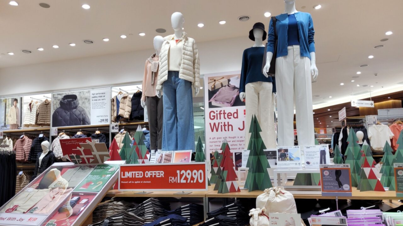 Kuala Lumpur, Malaysia - Dec 23, 2024: Uniqlo store showcasing winter apparel on mannequins with holiday-themed decorations and a limited-time offer sign promoting seasonal discounts.