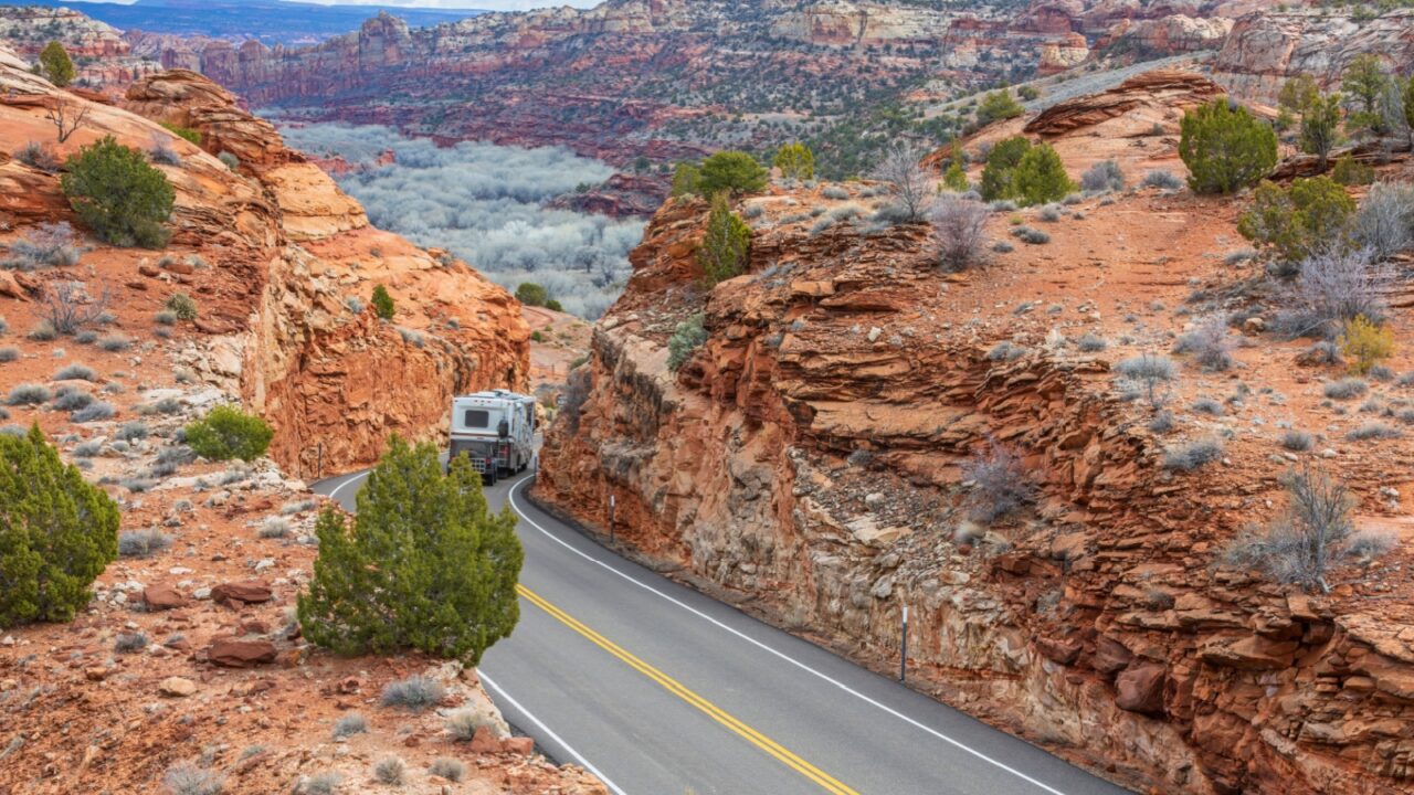 A scenic drive through Utah's Byway 12, surrounded by red rock canyons and desert landscapes, featuring a winding road perfect for road trips and RV adventures.