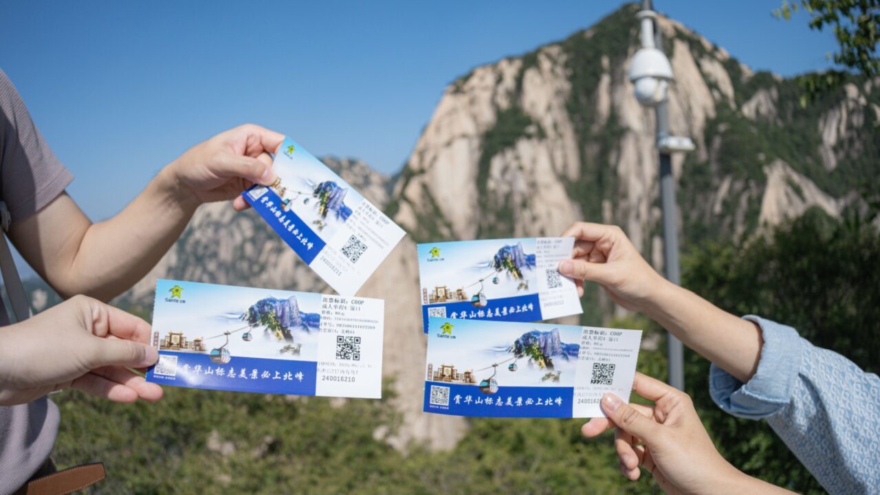 15-06-2025,Huashan, SHAANXI Province, China: Hands holding 'Huashan mountain north cable car tickets' famous world theme natural park, for visit to huashan Mountain.