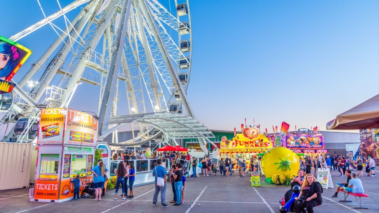Phoenix, Arizona - October 25, 2017: Fairgoers purchase tickets and line up to ride the La Grande XL Ferris wheel at the Arizona State Fair in Phoenix.