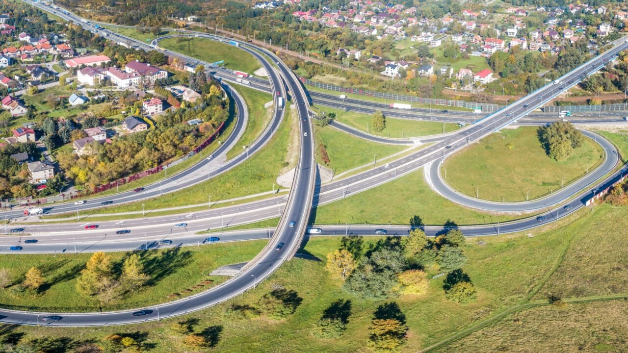 Highway multilevel crossing. Spaghetti junction on A4 international highway with Zakopianka road and railway, the part of freeway around Krakow, Poland. Aerial wide panorama from above
