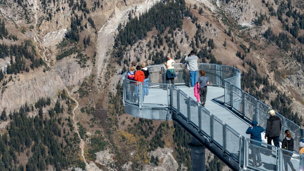 Jackson Hole Ski Resort, Wyoming, USA - October 6, 2023 - Incidental people enjoying the 360 degree views of the Teton Range from the Grand Teton Skywalk on the top of Mount Rendezvous