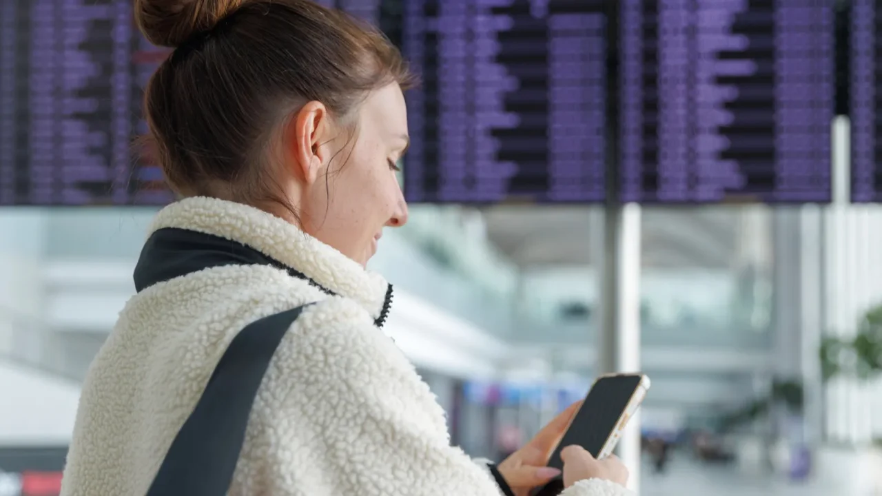 a person wearing a cozy jacket looks at their smartphone