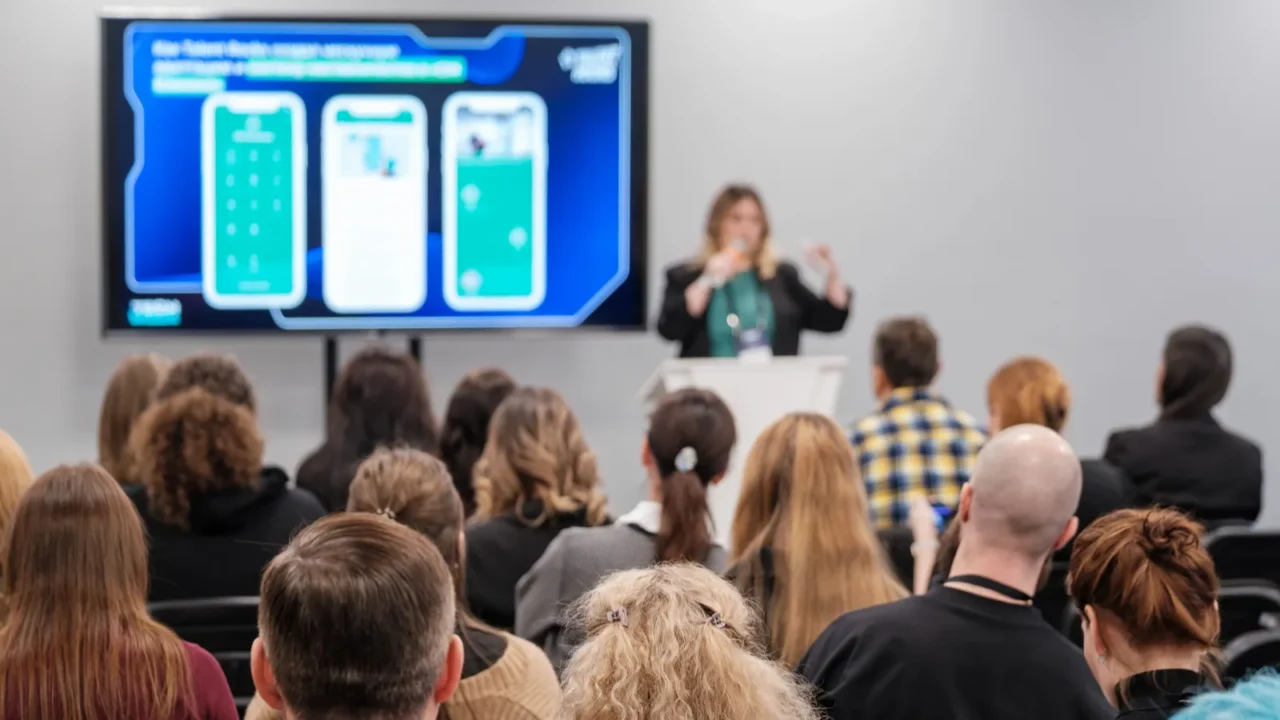audience members listen to a presentation at a conference focusing