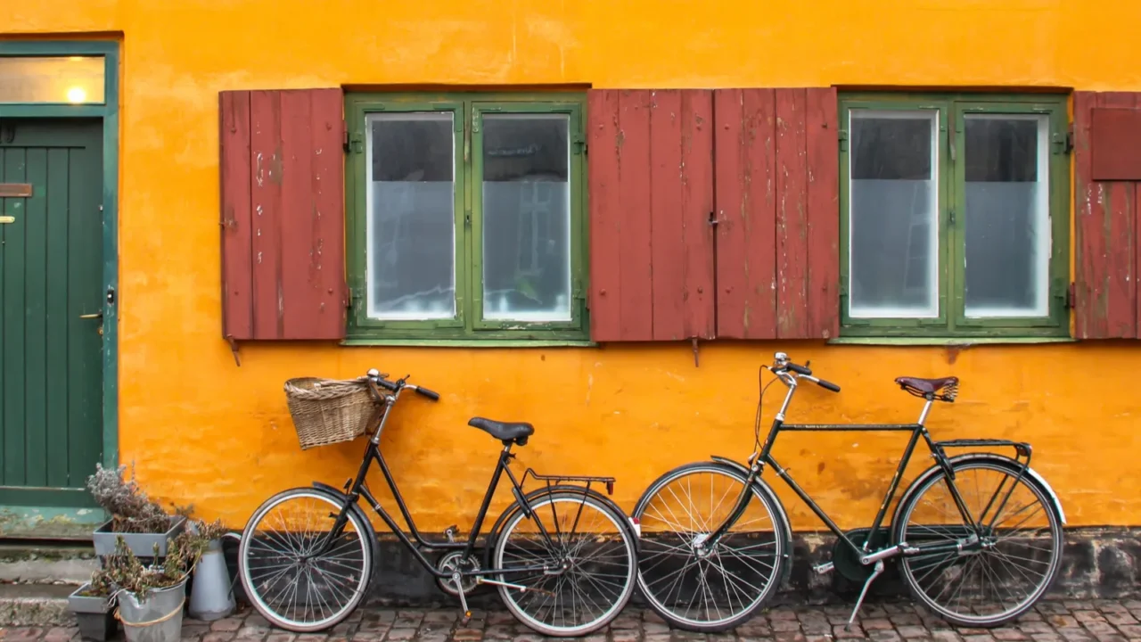 bicycles in front of an yellow orange house facade in