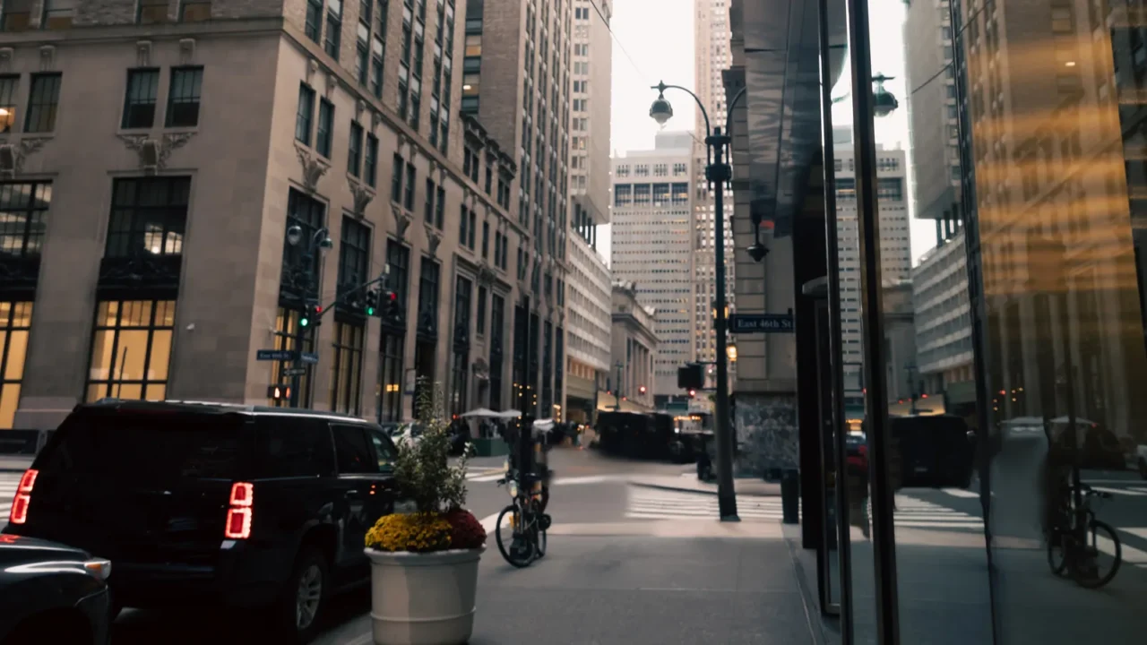 car road and sidewalk between modern buildings of urban street