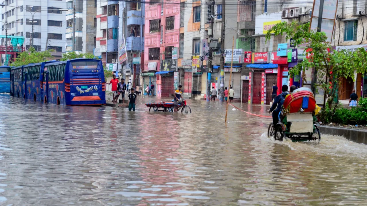 citizens and vehicles try to moves through the waterlogged streets