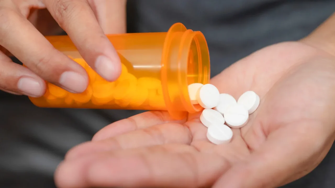 close up of woman taking in pill she is pours